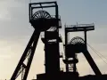 Dwie wieże szybowe kopalni węgla na tle nieba. Zastanawiasz się, ile zarabia górnik?
