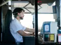 Mężczyzna za kierownicą autobusu, zastanawia się, ile zarabia kierowca autobusu.