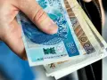 Dłoń trzyma polskie banknoty 50 i 200 zł. To może być zgłoszenie darowizny od rodziców na ważny cel.