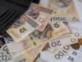 Portfel z polskimi banknotami 200 i 20 zł. Czy to już przekroczenie pierwszego progu podatkowego?