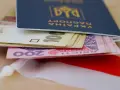 Ukraiński paszport z pieniędzmi, symbolizujący nadzieję na godną emeryturę dla Ukraińców w Polsce.