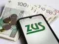 Pieniądze i smartfon z logo ZUS. Sprawdź, do kiedy ZUS dla firmy jednoosobowej.