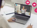 Dziewczyna w słuchawkach uczy się zdalnie na laptopie, gdzie nauczycielka prowadzi lekcję.