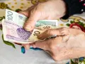 Dłonie liczą polskie banknoty. Zastanawiasz się, w jakim miesiącu najlepiej przejść na emeryturę, by mieć więcej pieniędzy?