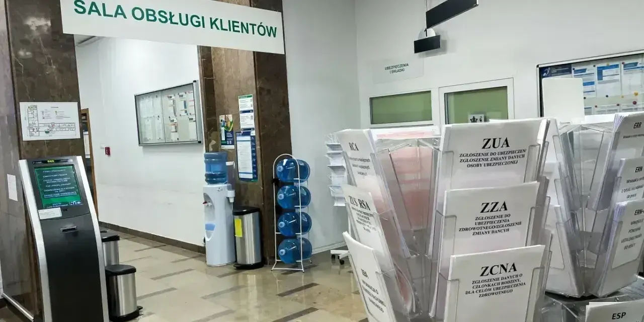 Sala obsługi klienta z terminalem, dystrybutorem wody i stojakami z formularzami ZUS, np. ZUA, ZZA, ZCNA. rp7.
