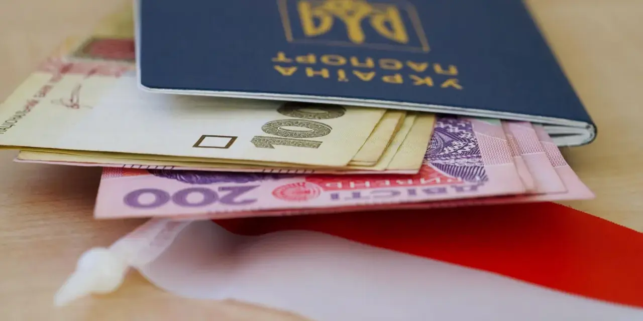 Ukraiński paszport z pieniędzmi, symbolizujący nadzieję na godną emeryturę dla Ukraińców w Polsce.