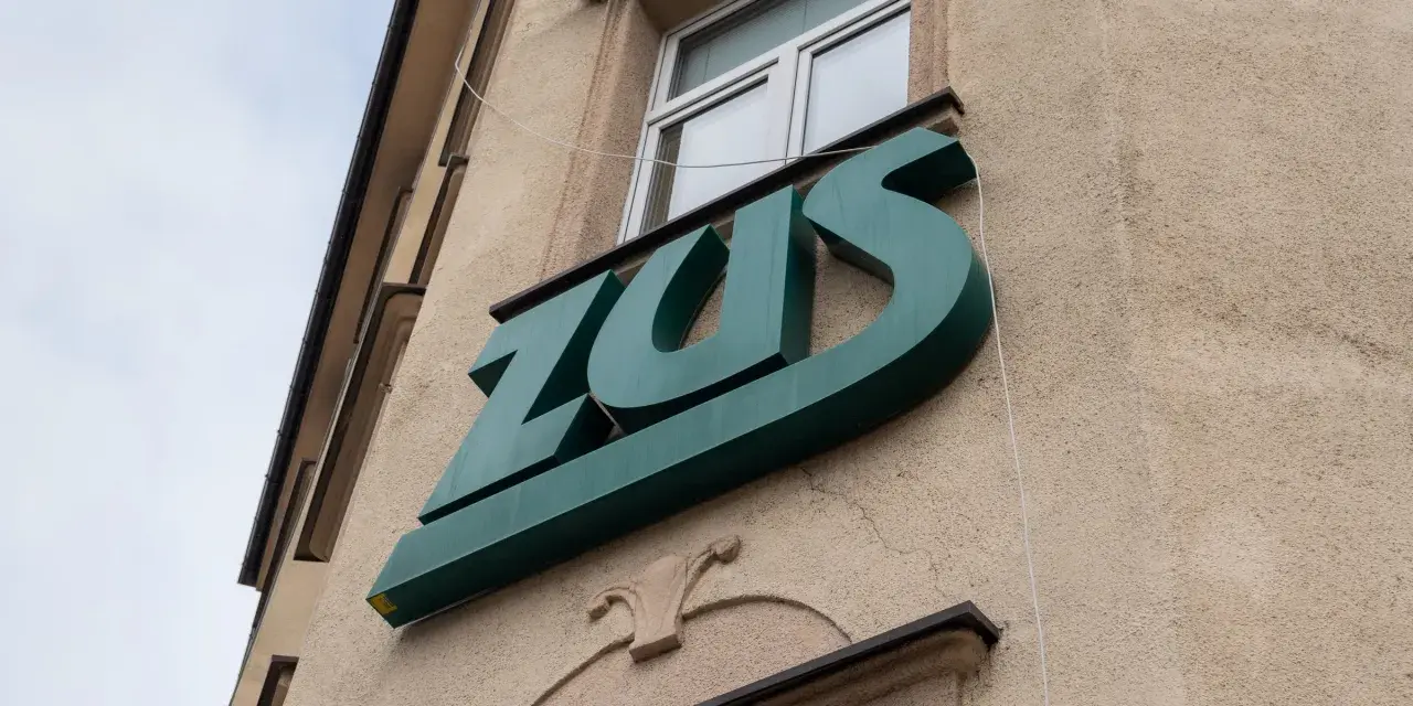 Zielone logo ZUS na budynku. To miejsce, gdzie można załatwić sprawy związane z ubezpieczeniem chorobowym.