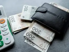 Portfel z pieniędzmi i kalkulatorem, sugerujące planowanie finansowe i próg podatkowy 2026.