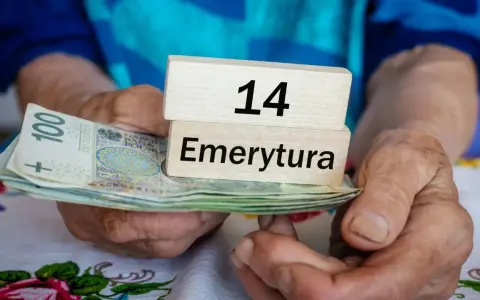 Dłonie trzymają banknoty i drewniane klocki z napisem "14 Emerytura". Tabela emerytura brutto netto jest w tle.
