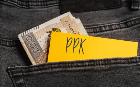 Karta z napisem "ppk" i banknoty w tylnej kieszeni dżinsów. Decyzja o rezygnacji z PPK.
