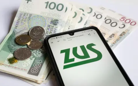 Na ekranie telefonu widnieje logo ZUS. Obok leżą polskie banknoty i monety. To może być druk z15 związany z finansami.