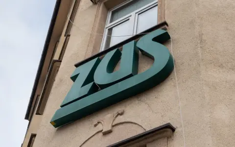 Zielone logo ZUS na budynku. To miejsce, gdzie można załatwić sprawy związane z ubezpieczeniem chorobowym.
