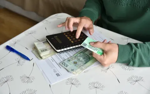 Ręce liczą pieniądze i dokumenty ZUS, przygotowując się do złożenia wniosku o rentę chorobową.