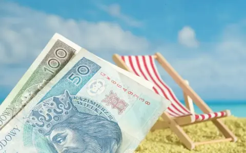 Pieniądze na plaży, leżak i błękitne niebo. To idealne połączenie, by cieszyć się zasłużonym świadczeniem urlopowym.