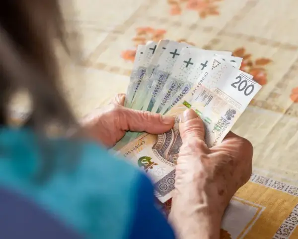 Dłonie liczą banknoty 200 zł. Zastanawiam się, ile można dorobić do renty, by mieć więcej takich pieniędzy.