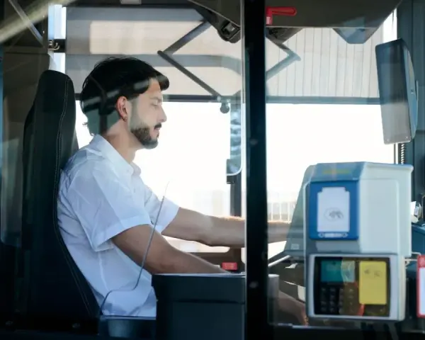 Mężczyzna za kierownicą autobusu, zastanawia się, ile zarabia kierowca autobusu.