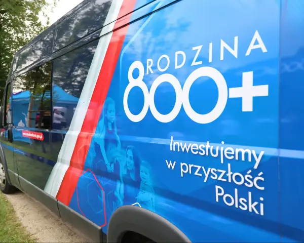 Niebieski van z napisem "RODZINA 800+" i hasłem "Inwestujemy w przyszłość Polski". Widoczne zmiany w 800 plus.