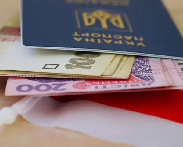 Ukraiński paszport z pieniędzmi, symbolizujący nadzieję na godną emeryturę dla Ukraińców w Polsce.