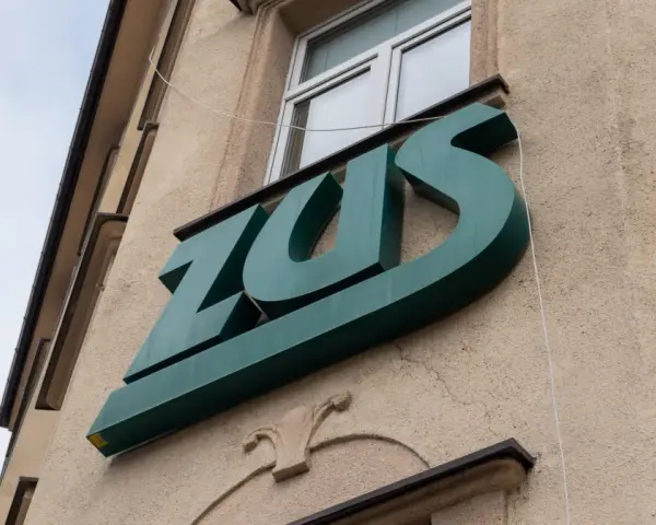 Zielone logo ZUS na budynku. To miejsce, gdzie można załatwić sprawy związane z ubezpieczeniem chorobowym.