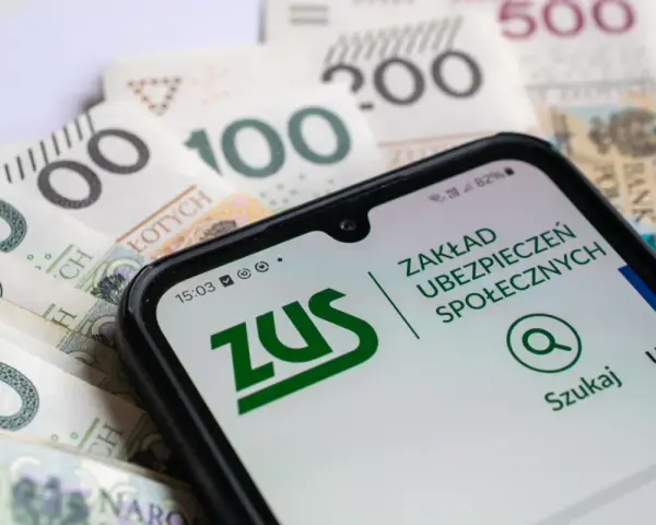 ZUS na smartfonie obok polskich banknotów. Planowanie przeliczenia emerytury staje się prostsze dzięki cyfrowym narzędziom.