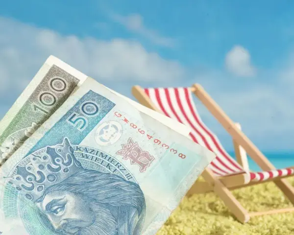 Pieniądze na plaży, leżak i błękitne niebo. To idealne połączenie, by cieszyć się zasłużonym świadczeniem urlopowym.
