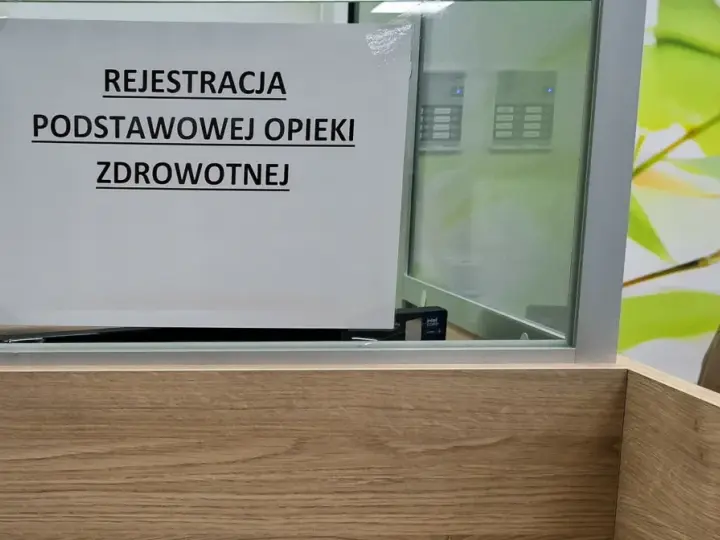 Tabliczka "Rejestracja Podstawowej Opieki Zdrowotnej" w poczekalni. Ubezpieczenie zdrowotne to podstawa.