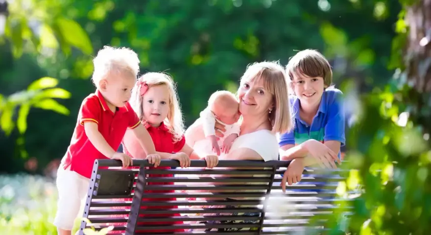 Szczęśliwa mama z czwórką dzieci, marząca o emeryturze dla matek 4 dzieci, które pracowały.