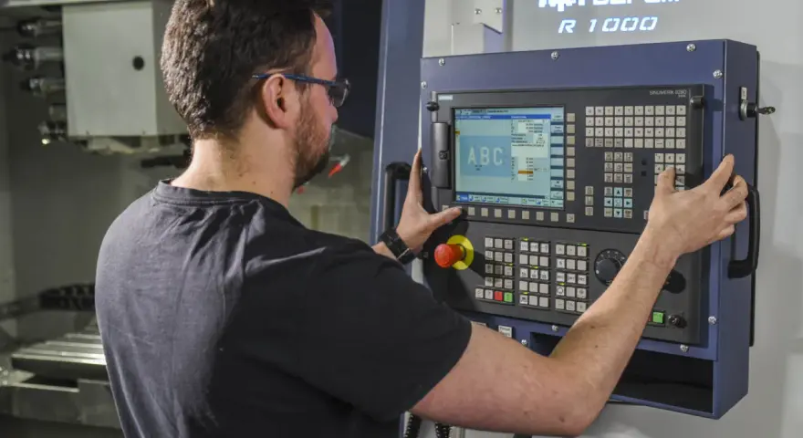 Operator CNC przy panelu sterowania. Dobra praca to wysokie operator cnc zarobki.