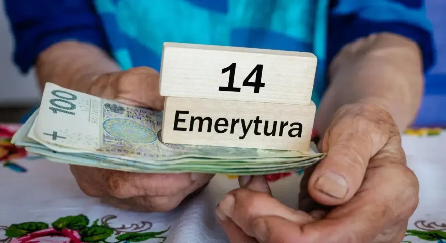 Dłonie trzymają banknoty i drewniane klocki z napisem "14 Emerytura". Tabela emerytura brutto netto jest w tle.