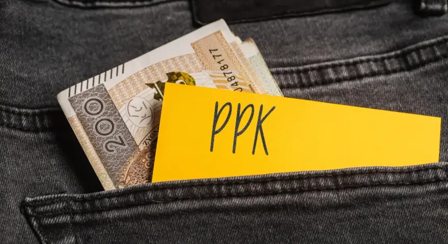 Karta z napisem "ppk" i banknoty w tylnej kieszeni dżinsów. Decyzja o rezygnacji z PPK.
