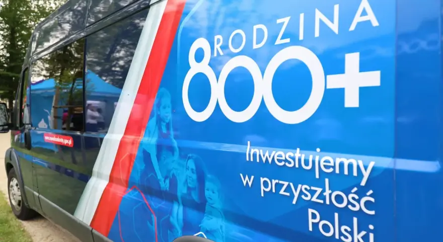 Niebieski van z napisem "RODZINA 800+" i hasłem "Inwestujemy w przyszłość Polski". Widoczne zmiany w 800 plus.