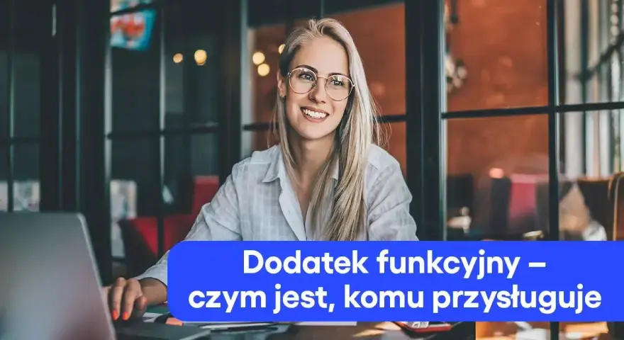 Uśmiechnięta blondynka w okularach pracuje przy laptopie. Na ekranie widoczny tekst: "Dodatek funkcyjny – czym jest, komu przysługuje".