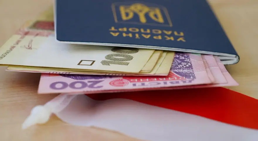 Ukraiński paszport z pieniędzmi, symbolizujący nadzieję na godną emeryturę dla Ukraińców w Polsce.