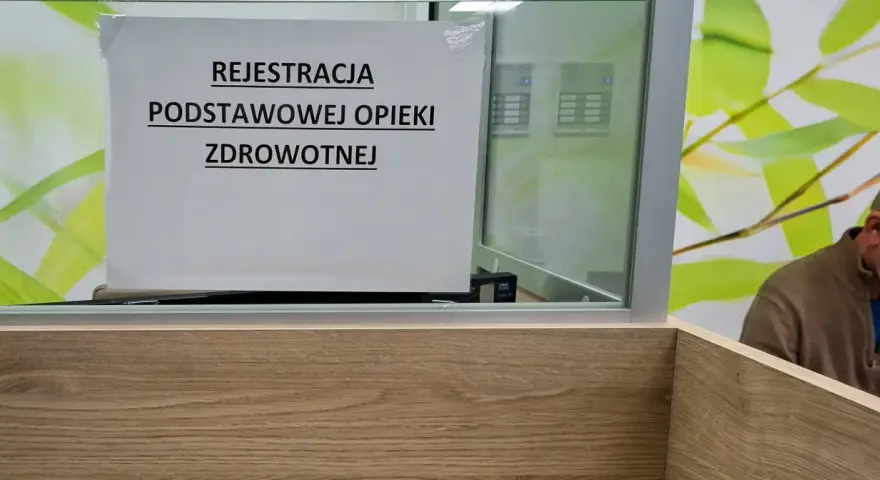 Tabliczka "Rejestracja Podstawowej Opieki Zdrowotnej" w poczekalni. Ubezpieczenie zdrowotne to podstawa.