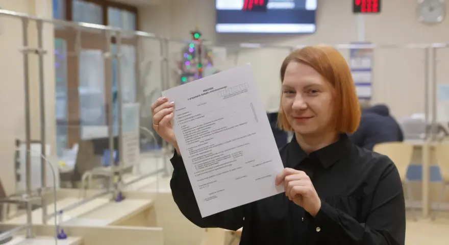 Kobieta trzyma w ręku wniosek o przyznanie dodatku mieszkaniowego.