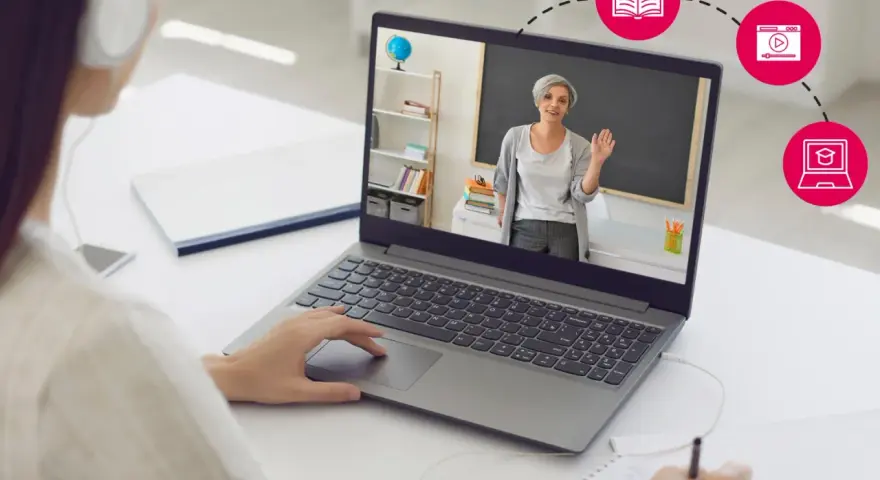 Dziewczyna w słuchawkach uczy się zdalnie na laptopie, gdzie nauczycielka prowadzi lekcję.