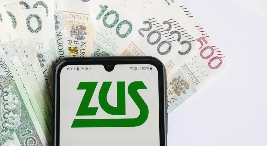 Telefon z logo ZUS na tle polskich banknotów. Oczekujesz zwrotu nadpłaty?